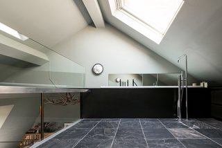 Formerly Home to an Artist and Knitwear Designer, a Commercial Space-Turned-Dwelling Hits the Market - Photo 7 of 10 - When you climb the spiral stairs, you’re led to the en-suite bathroom on the mezzanine level, which revels in natural light—thanks to a substantial angled skylight above, 