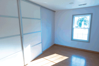 Large rolling doors create easy-to-maneuver dividers between the living space and the bedrooms.