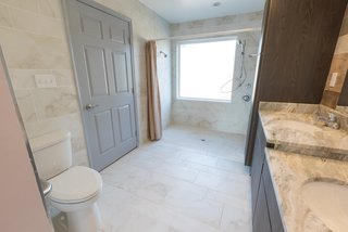 The final result includes an accessible layout with plenty of storage space and dual sinks at different levels for both the adults and the young ones.