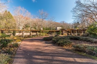 From the front of the house, you can see that Tirranna was designed in a hemicycle shape, which Frank Lloyd Wright was known for. The main entrance to the house sits under the chimney stack near the center, while the covered breezeway on the left leads to a four-car parking structure, the greenhouse, and the caretaker’s quarters. 