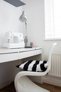 Silvia spends a lot of her free time sewing and crafting, which she does in her makeshift studio space—shown here with a desk from Ikea. This photo also shows one of the cushions she made herself, which is sewn with the same fabric as the shower curtain in the bathroom.