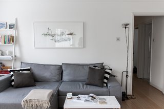 For the small yet open living space, Silvia brought in a sofa bed from Made.com, which can be easily pulled out for overnight guests. To the right of the sofa is the FLOS Toio Modern Floor Lamp by Achille and Pier Giacomo Castiglioni, while the artwork above the sofa is by Laura Jordan. 