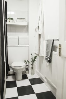 Though their wish was to redo the whole bathroom, they decided to stick to a budget and preserve the original black-and-white tiles, which are common in London flats. They ended up keeping it simple and accentuating the color palette with a black-and-white shower curtain and new white storage elements.
