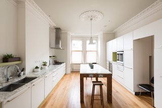 Filled with extensive new cabinetry, marble surfaces, updated appliances, and a large island with embedded power outlets, the kitchen is set up perfectly for entertaining. You can see that the architectural moldings have been preserved, but updated with a fresh coat of paint.