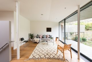 By following a set of steps, you enter into a sitting room that’s part of the extension that was built towards the rear of the house. A large sliding wall of glazed glass from Fineline opens to the yard.