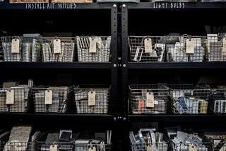 Their materials library is partitioned from the open space with charred wood walls that have been turned black with the Japanese Shou Sugi Ban technique. Shown here is the storage side of this wall.
