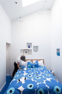 Bright Colors and Sleek White Oak Fill This Playful Lake Tahoe Loft - Photo 4 of 9 - The cut-outs were added into the bedroom walls while the bed is outfitted with one of Marimekko's classic duvet covers.