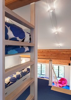 Bright Colors and Sleek White Oak Fill This Playful Lake Tahoe Loft - Photo 5 of 9 - When the family visits the vacation home, the kids sleep in custom bunk beds in the open loft. 