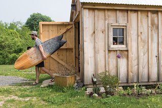 Indoek’s New Book Shares a Glimpse Into the Homes of Creative Surfers - Photo 9 of 11 - As a photographer with an obsession with the sea, Nick LaVecchia recently finished building his new eco-friendly home in York, Maine. He spent two years researching the technical side and benefits of passive solar design. He’s shown here carrying his 5’10" fish board that he made himself. He learned directly from his brother Mike, who started Grain Surfboards in 2005.