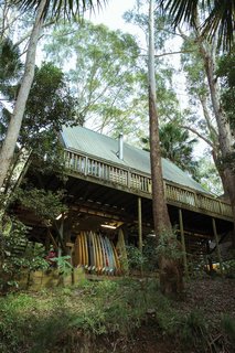 Indoek’s New Book Shares a Glimpse Into the Homes of Creative Surfers - Photo 2 of 11 - Damion Fuller and Fern Levack live with their son Jake in an A-framed tree house that’s nestled in a forested grove directly next to Royal National Park—just an hour outside of Sydney. This view gives a peek at just one of his quivers from his incredibly extensive surfboard collection.