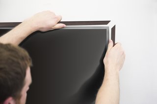 The physical bezel of the frame is customizable with white, black, or wood veneer. Sensors hidden on the bottom of the frame ensure that it doesn’t waste power when no one is in the room.