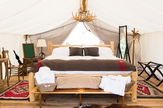 Get the Modern Camping Experience You Crave at One of These New Secluded Retreats - Photo 3 of 11 - At the Vail location, designer Cassie Novick sourced western, ranch-inspired furnishings from local markets, estate sales, and flea markets. In the tents, you’ll find Native American-inspired details, special books, and maybe even some vintage board games. 