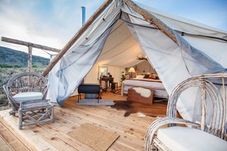 Get the Modern Camping Experience You Crave at One of These New Secluded Retreats - Photo 4 of 11 - Each Signature Luxury Tent is built with wood floors and a canvas shelter. They’re equipped with electricity, a working chandelier, high-quality bed linens, and a French press coffee bar. You’ll also stay extra warm with a wood burning fire stove that’s placed in every room, as well as a tea kettle that's at your disposal.