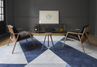 A pair of Finger Chairs by Cuchara are shown here in front of one of their consoles. It’s created with walnut and black vinipiel for durability. 