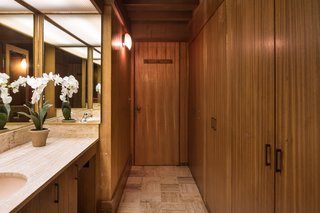 The only full privacy that exists in the main house—since everything is surrounded by glass—is in a cube that Jay placed in the center of the house. It’s seven feet tall, covered with a thin sheet of fiberglass to let the light stream in from a skylight, and holds two-and-a-half bathrooms. The woodworking here is done with a mahogany finish.