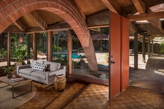 The original red front door leads directly into the living room, which has oak parquet flooring and a radiant heating system throughout that still works to this day. 