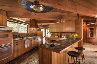 In the kitchen, the mother of pearl light fixture—which was installed by the Little family in the 1970s—is surrounded by three concentric rings of dark blue tiles from Sausalito-based Heath Ceramics. Liebermann installed Heath tiles in the kitchen, baths, pool, and fountain.