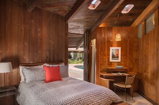 Connected by the same room but 20 yards away from the main house, sits the pool or guest house, which has one bedroom and one bathroom. Liebermann built the small round desk shown here, which sits under original porthole skylights.