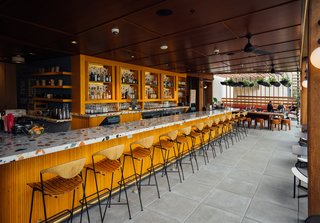 The bar is lined with vintage stools by Arthur Umanoff, which OMFGCO sourced from all over the world via 1stdibs, Pamono, Etsy, and more. Fritz Mesenbrink of OMFGCO tells us, "It was challenging to get that many of his stools in the same place, but we got them, and had them all restored beautifully."