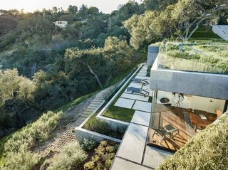 Constructed predominantly with structural concrete, the house can safely accommodate long, column-free spans and larger cantilevers, allowing it to visually integrate with the land.