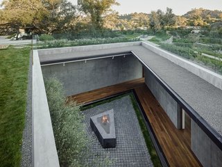 A courtyard on the lower level brings sunlight into the subterranean corridor where the bedrooms are located. 