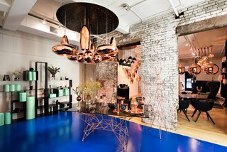Twenty Minutes With:
Tom Dixon - Photo 1 of 2 - Tom Dixon's new Manhattan showroom at 19 Howard Street, featuring various pendants and tabletop items from the designer's Copper series, and the Pylons dining table, made from a copper-plated steel rod base and smoked glass surface.