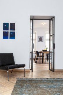 A new custom glass door separates the living area from the kitchen and dining area while allowing natural light to filter through. When the living area is used as a guest room, the resident simply draws a curtain for extra privacy.