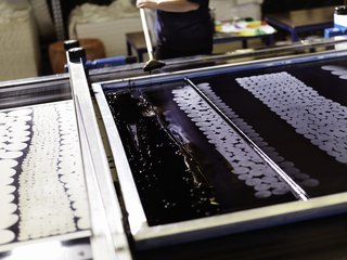 Each layer of color is then spread across the fabrics by hand, transferring dyes through the individual silk screens. In this process, different hues are applied individually, one layer at a time, creating Marimekko's signature for slightly imperfect, overlapping planes of rich color.
