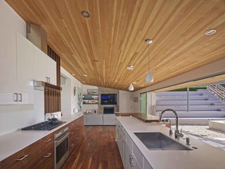 "By removing a few interior walls, reconfiguring a couple of others and opening up the kitchen/living/dining areas, we were left with a wonderfully livable floor plan with a great balance of public and private space," says Southerland. A large, open galley style kitchen and mirrored planes of wall paneling visually expand the home's interior perspective.
