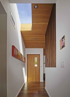 Striated wood paneling and new skylights give light and dimension to the renovated entryway. 