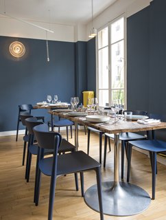 Sixty-five seats are accommodated across Belle Maison's two floors. Bonaventure worked with craftsmen to create the custom chestnut-top tables; the circular wall sconces are vintage.