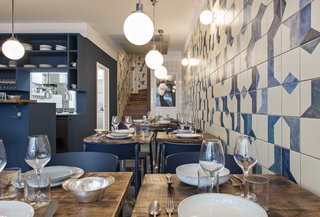 The hand-painted ceramic tile wraps along the wall and continues up the stairwell. Named after Belle Maison, after the owners' favorite beach, the restaurant is focused on seafood dishes.