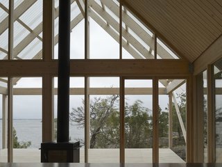 The open-plan interior measuring roughly 430 square feet, with a bedroom and a living room with wood-burning stove on the ground level, and a lofted level above it.