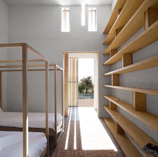 Openstudio worked with local builders, using a palette of regional materials: patterned brick, white ceramic tiles, and roughcast lime-washed plaster. Custom built-ins accentuate the linear light and shadow cast by the elongated windows.