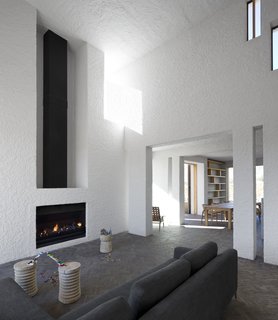 Soaring ceilings and a fireplace mark the home's main living area.