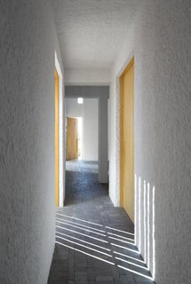 By day, the home's rectilinear windows cast an artful composition of linear shadow and light.