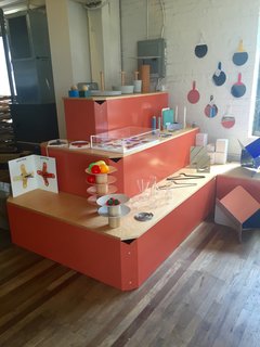 A display system holds selections of the brand's most popular pieces, including the General tray, bowl, and bucket (top) and the stackable powder-coated steel Platform bowls (bottom). A selection of Utility mirrors by Visibility with different colors of rubber tool grip hang on the wall.