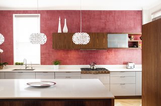 The kitchen's red Venetian plaster walls are a nod to a detail in the family's previous apartment. The walnut and lacquer kitchen system is by Henrybuilt.<br><br>Photo by Howie Guja<br>Styling by Gorilla Styling