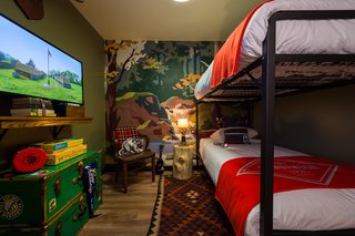 The media room features custom-designed bunks with Camp Wandawega for Land of Nod bedding. The mural recalls paint-by-number landscapes.