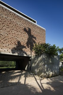 The three-story structure serves as both a home and architectural studio, with parking for four cars on the ground-level carport—all on a 2,700-square-foot plot of land.