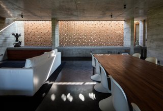 The primary living area opens to the main volume below it. The perforated brick walls aid with heat management.