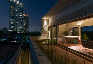 A roof deck offers views of both the city and the surrounding marsh. The roof's biological ponds regulate stormwater, while its edible herb gardens and paddy fields help to keep the interior of the home cool despite the tropical heat. 