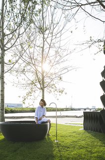 A 3D-printed bathtub with a Vola spout sits within the pocket park.