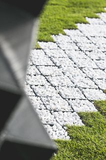 A pebble path echoes the patterns of the printed cells and the concrete that fills them.