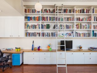 A ladder leads to built-in book shelves. 