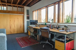 Vintage Soft Pad chairs by Charles and Ray Eames for Herman Miller (an eBay find) and matching new Eames desk and storage units, also from Herman Miller, furnish a workspace on the mezzanine level. "When we're both at home we speak to each other all the time," William says of the openness of the house. 