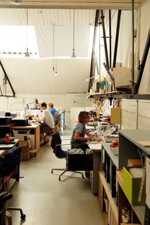 The design team works in the mezzanine, which is reached by a spiral staircase. Here they make models, finish in-house products, and work on prototypes.