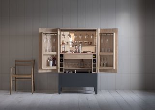 The Frans drinks cabinet, which Pinch showcased at Decorex International during the London Design Festival, features a satin copper lacquered work surface, adjustable shelves to allow for varying bottle and glass heights, a stained and silicon-lined drinks trough, wine storage, and space for hanging glasses.