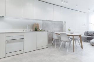 White appliances by Karim Rashid for Gorenje pair with concrete floors in the apartment's kitchen.