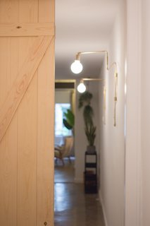 Once dark and "spooky," the narrow hallway is now illuminated with LED lights chosen for their warm color. Diffused glass helps soften the glow.